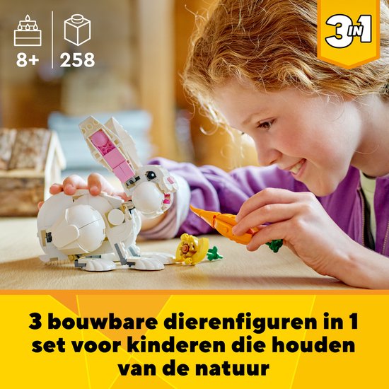 Une fille construit un lapin LEGO blanc.