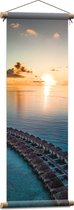WallClassics - Textielposter - Rij Vakantiehuisjes op het Water met Ondergaande Zon - 30x90 cm Foto op Textiel