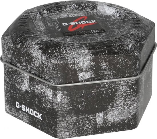 Octagonale G-SHOCK verpakking met distressed zwart-wit patroon en zilveren draadsluiting.