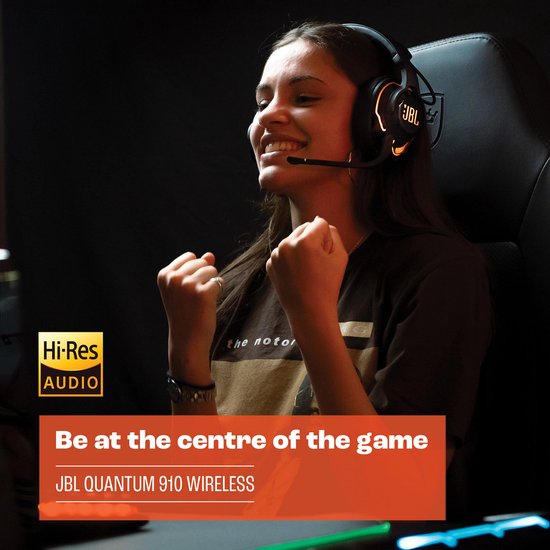 Vrolijke vrouw met een JBL Quantum 910 WIRELESS headset, met oranje gloed.