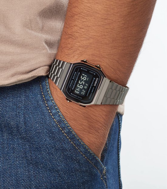 Zilverkleurig Casio horloge met metalen band gedragen om een pols, met een zwart digitaal display.