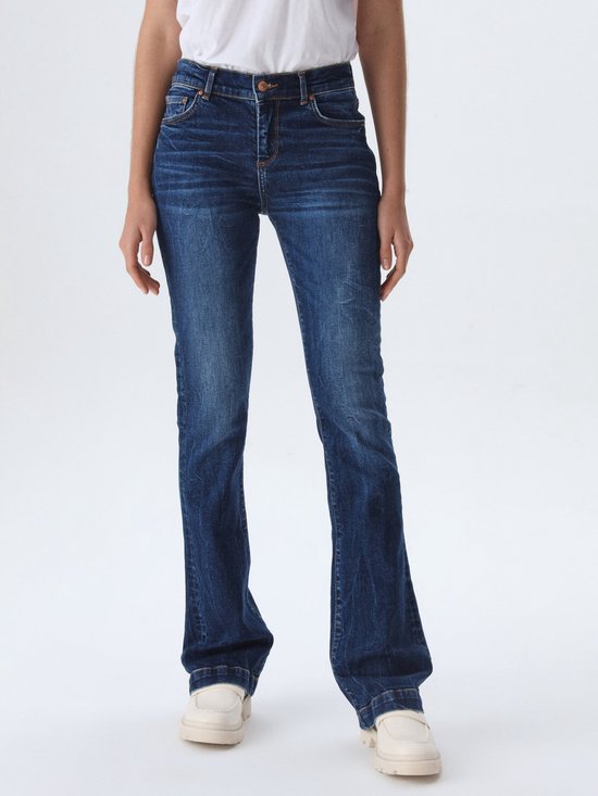 Model draagt een donkerblauwe flared jeans, de voorkant van LTB.
