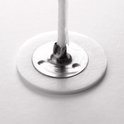 Close-up van een witte kaarsenlont met een metalen voetje.