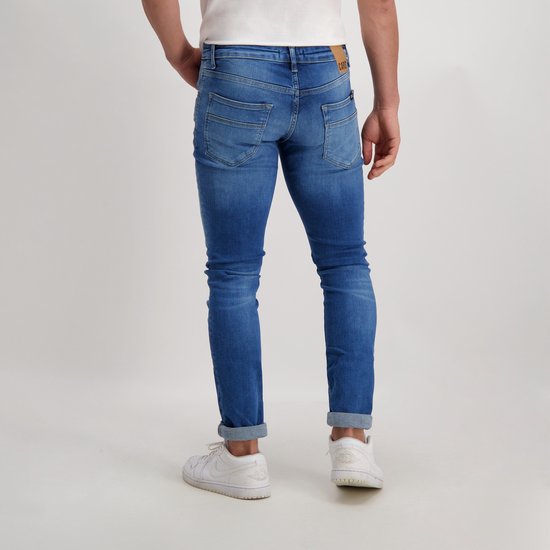 Achterkant van een man in een spijkerbroek met lichte wassing, omgeslagen pijpen.