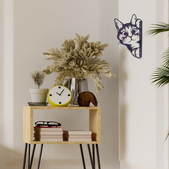 Zwart metalen kattenfiguur op een muur, met grote ogen die nieuwsgierig om de hoek kijken.