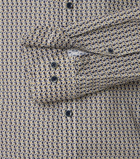 Detail van een overhemd met een geometrisch patroon in blauw, wit en geel. Zichtbare knopen en een opgestikte borstzak.