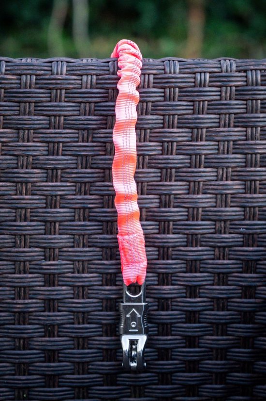 Een roze en oranje gestreepte elastische hondenhalsband met clip, hangend aan een bruine, gevlochten achtergrond.