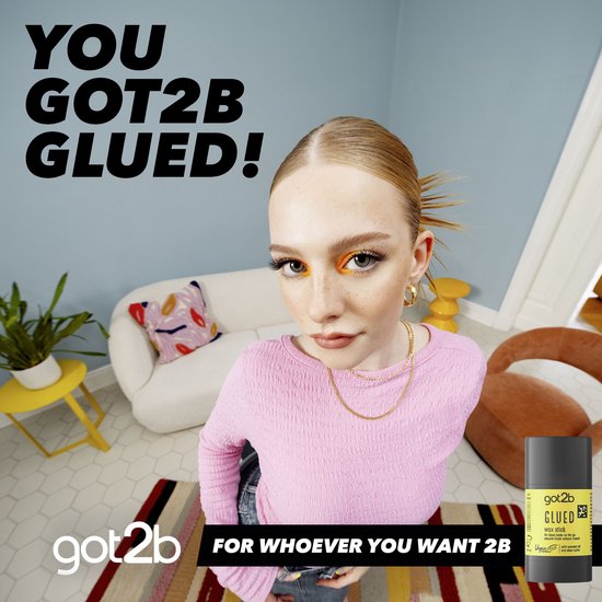 Jonge vrouw met oranje oogmake-up en roze trui, met een Got2b Glued wax stick op de voorgrond.