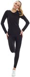 Vrouw met blonde paardenstaart in zwart sportshirt en legging, staand.