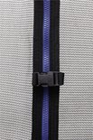 Detailopname van rits met blauwe tandjes en zwarte band, met zwarte gesp aan de zijkant op trampoline net.