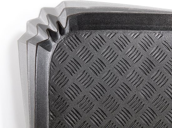 Gros plan du coin côtelé d'un tapis de coffre noir à motif diamant.