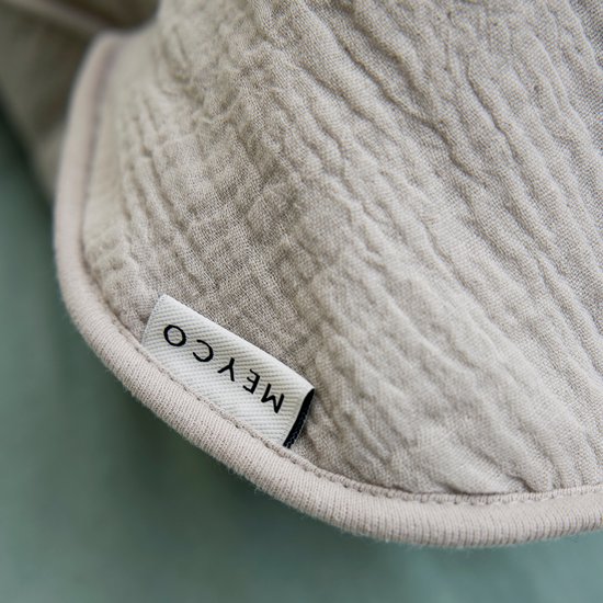 Detail van het grijze, hydrofiele katoen van een Meyco babyslaapzak met label.