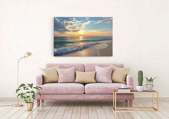 Canvas schilderij met zonsondergang aan zee, hangend boven een roze bank.