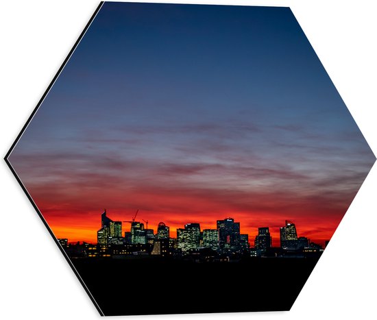 Dibond Hexagon - Zonsondergang achter Gebouwen met Verlichting - 40x34.8 cm Foto op Hexagon (Met Ophangsysteem)