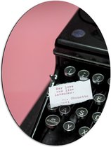 Dibond Ovaal - Quote op Wit Papier Liggend op Zwarte Vintage Typemachine op Roze Achtergrond - 51x68 cm Foto op Ovaal (Met Ophangsysteem)