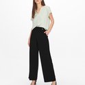 Model met zwarte wijde pantalon met hoge taille, sierknoop en steekzak.