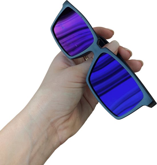 Hand met nagellak houdt een zwarte spionagebril met blauw gestreepte lenzen vast.