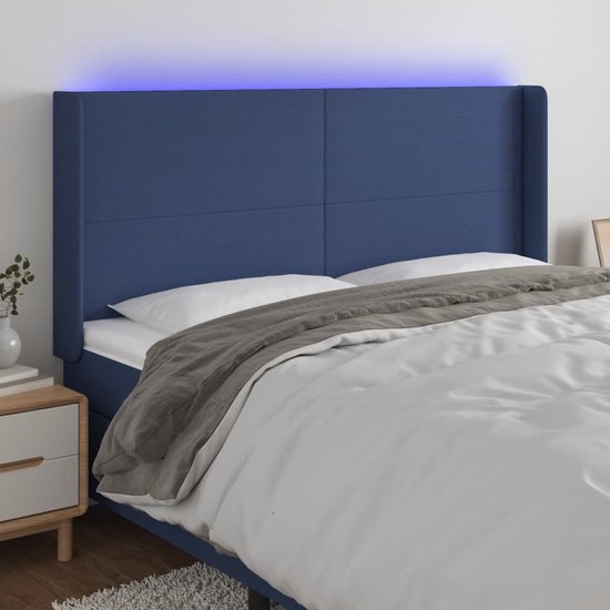 Tête de lit bleue en tissu avec éclairage LED au-dessus du lit, avec couette et table de chevet.