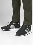 Zwarte Jack & Jones sneakers met grijze accenten en witte zool, gedragen door een model.