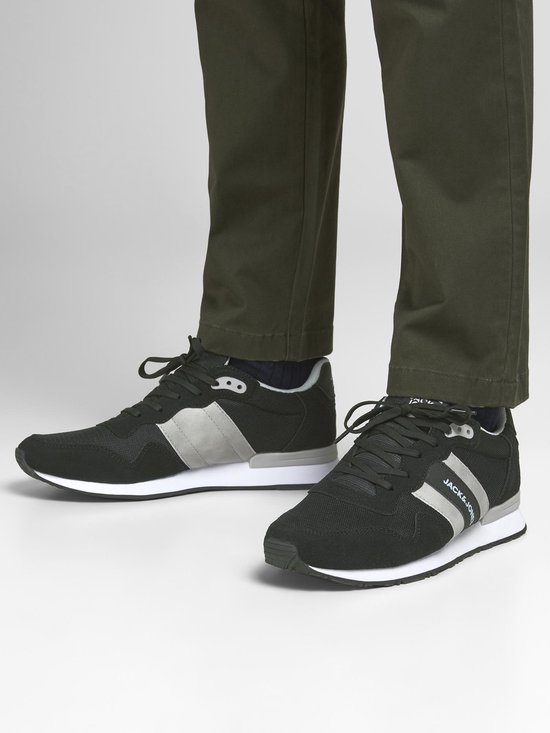 Zwarte Jack & Jones sneakers met grijze accenten en witte zool, gedragen door een model.
