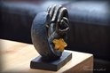 Zwarte hartvormige urn met gouden handen, met een amberkleurige glazen ster.