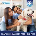 Een koppel wast hun Golden Retriever in een woonkamer.