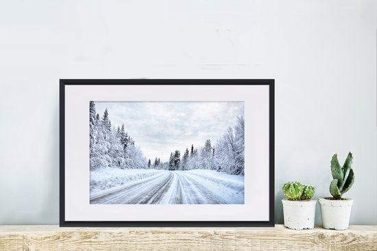 Photo en cadre - Une route enneigée entourée d'un cadre photo paysage d'hiver noir avec passe-partout blanc 60x40 cm - Affiche sous cadre (Décoration murale salon / chambre)