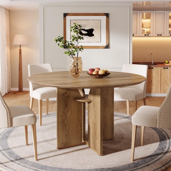 Ronde bruine eettafel met houten nerf en een X-vormig onderstel, met vier stoelen.