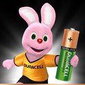 Roze Duracell konijn met gele T-shirt, houdt een groene Duracell AA batterij vast.