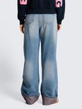 Achterkant van een wijde, lichtblauwe jeans met omgeslagen zoom.