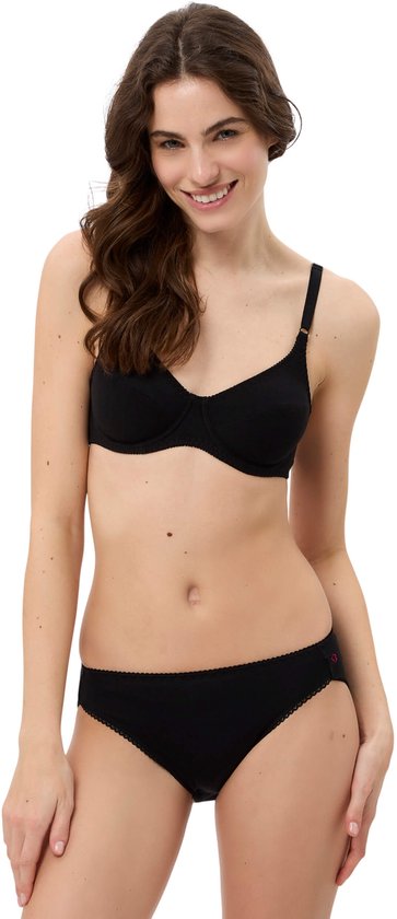 Model in zwarte beha en slip, lachend met handen op de heupen.