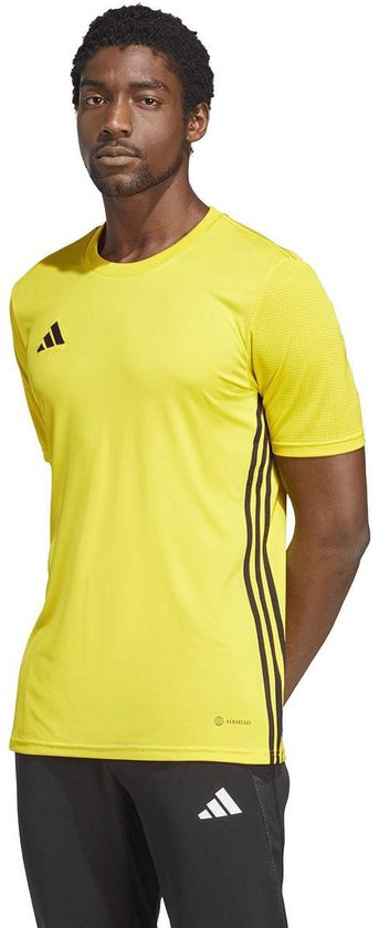 Gele Adidas sportshirt met korte mouwen, zwart Adidas logo op linkerborst en zwarte strepen aan de zijkant.
