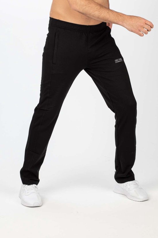 Zwarte joggingbroek met logo, gedragen door een man met witte sneakers.