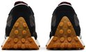Achterkant van twee zwarte New Balance sneakers met bruine, noppen-achtige profielzolen.