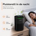 Zwarte luchtreiniger met groen verlicht display, naast slapende vrouw en baby. Toont fluisterstil 21 dB en zachte nachtmodus.