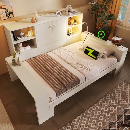 Wit uitschuifbed met opbergruimte en bureau aan de zijkant, met een bruine sprei en een nachtlampje.