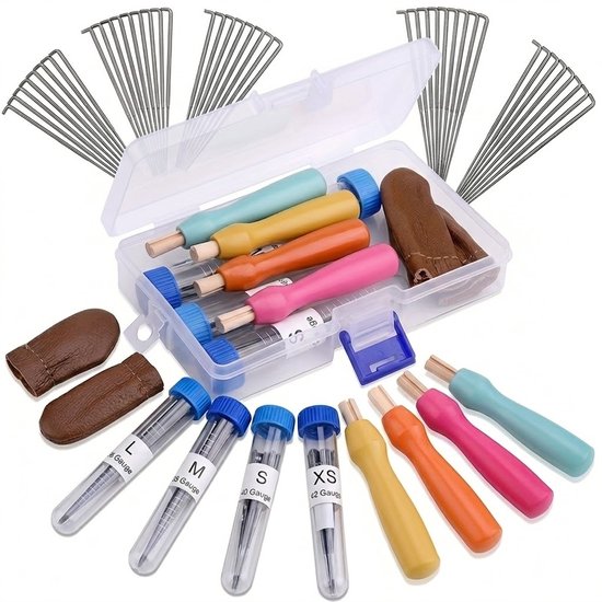 Boîte de rangement ouverte avec outils de feutrage, aiguilles en tubes (L, M, S, XS), et doigts protecteurs en cuir. Plus d'aiguilles et d'outils autour.