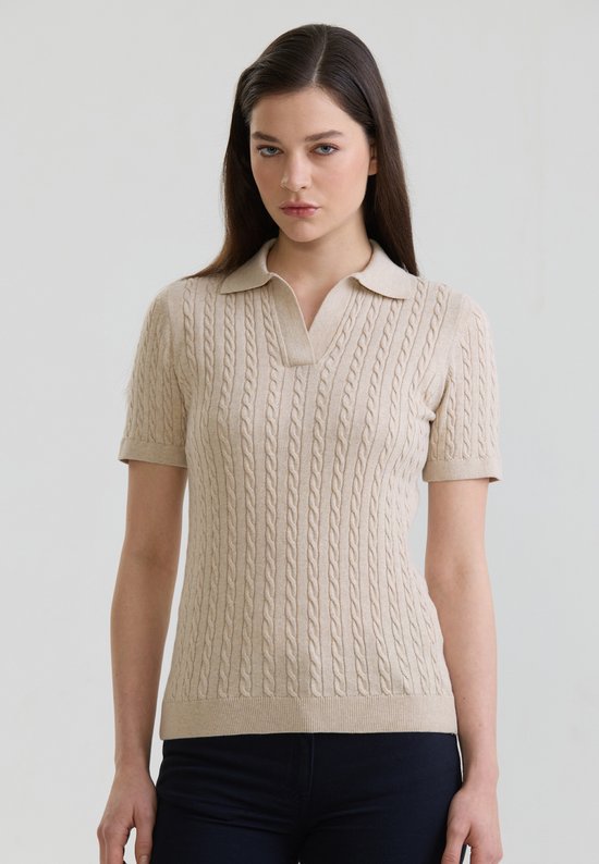 Polo beige pour femme à manches courtes, col en V et torsades. Le mannequin porte une taille M.