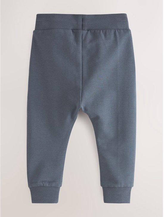 Een blauwe joggingbroek met elastische tailleband en enkelboorden.