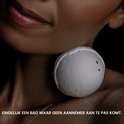 Schouder en nek van een vrouw met een wit badbruisbal op de huid.