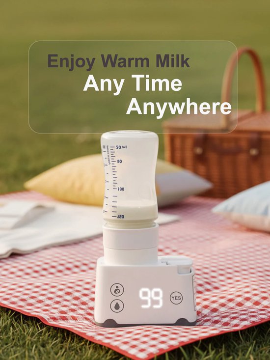 Flessenwarmer met melkfles op picknickkleed in het gras, met een mand op de achtergrond.