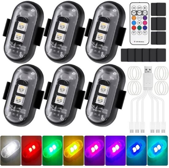 Six strobes LED ovales avec clips noirs, une télécommande et plusieurs câbles de chargement. Lampes en blanc, rouge, vert, jaune, rose, violet, bleu et cyan.