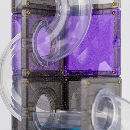 Gedetailleerde close-up van Connetix magneetblokken met paarse glittertegels en transparante buizen, met focus op de gebogen buis.