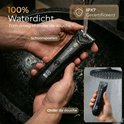 Zwarte Wellshave trimmer wordt afgespoeld onder een kraan en gebruikt onder de douche. 100% waterdicht, IPX7 gecertificeerd.