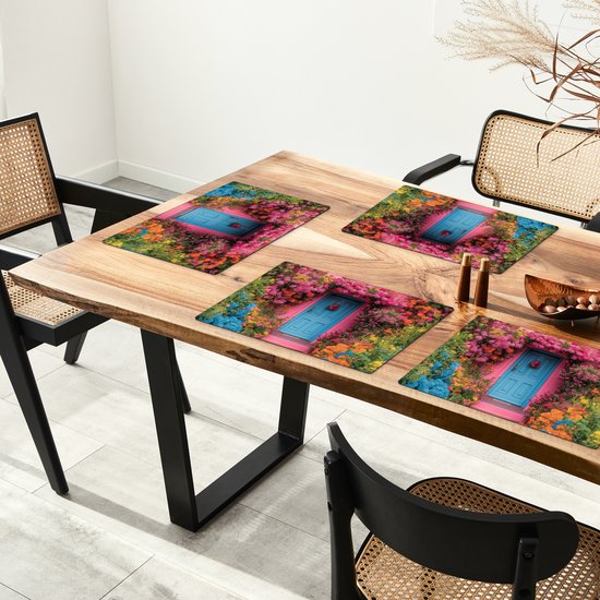 Sets de table avec un imprimé d'une maison rose avec une porte bleue, entourée de fleurs et de plantes colorées, sur une table en bois.