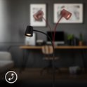 Zwarte staande lamp met verstelbare lampkop.