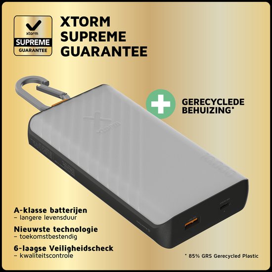 Lichtgrijze Xtorm powerbank met zonnepaneel, karabijnhaak en oranje accenten, met tekst over garantie en gerecyclede behuizing.