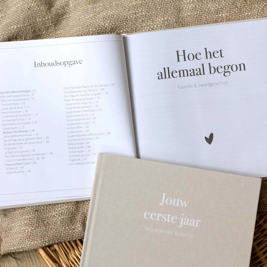 Open babyboek met de titel 'Hoe het allemaal begon' en inhoudsopgave.