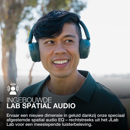 Man met groene JLab GO Lux ANC koptelefoon kijkt naar de zijkant, met tekst 'INGEBOUWDE LAB SPATIAL AUDIO'.