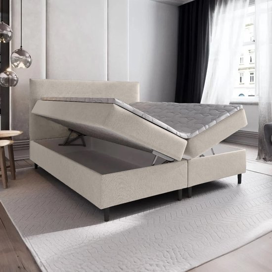 Beige boxspring met opbergruimte, 180x200 cm, met de matras omhoog geklapt.